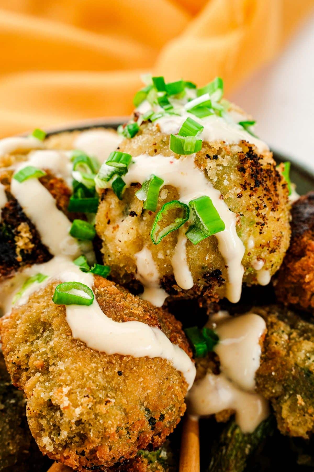 Bowl of broccoli fried and topped with sauce and chives