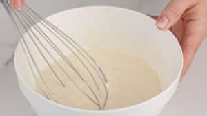 whisk in white bowl of batter