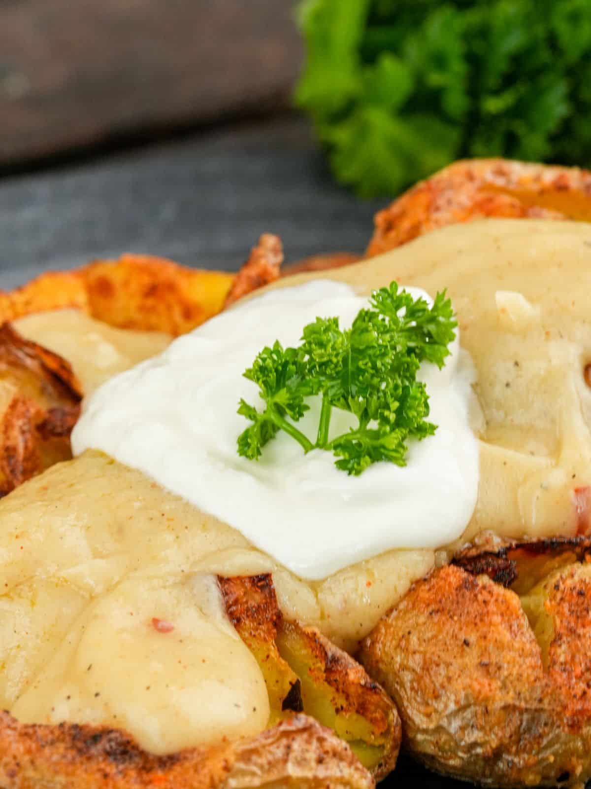 stack of fiesta potatoes topped with vegan cheese sauce on black plate