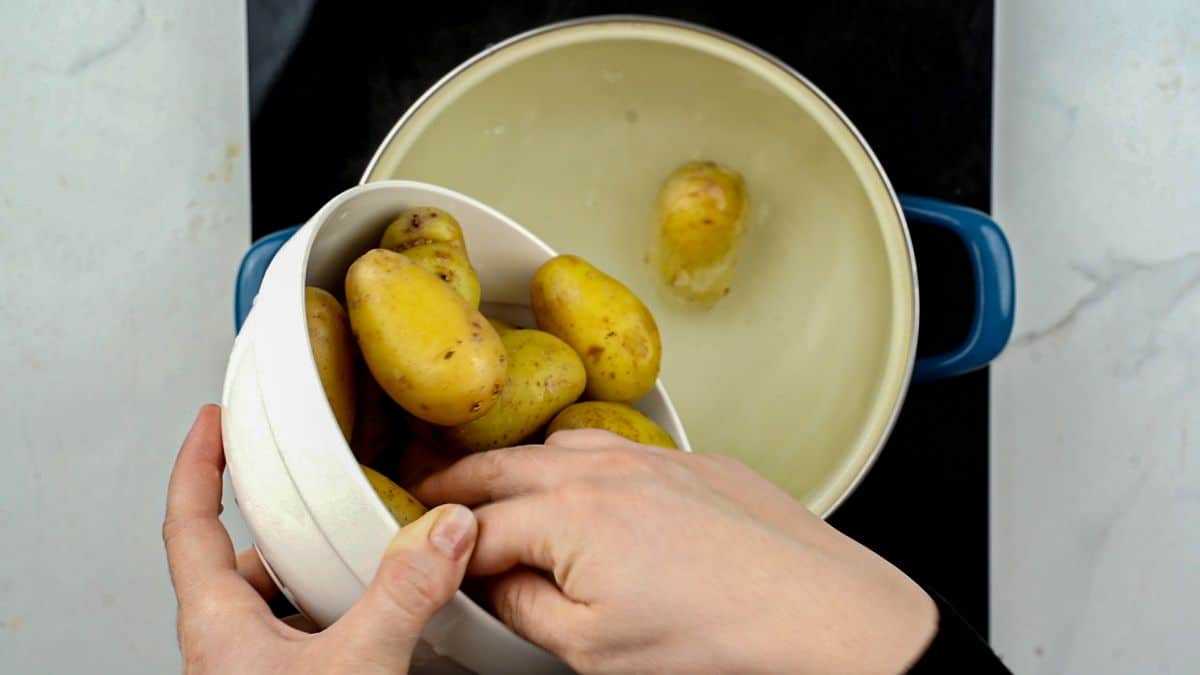 potatoes being put into a stockpot