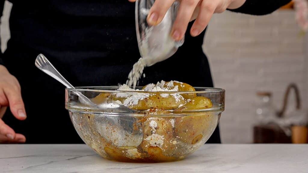 stirring cornstarch into potatoes in glass bowl