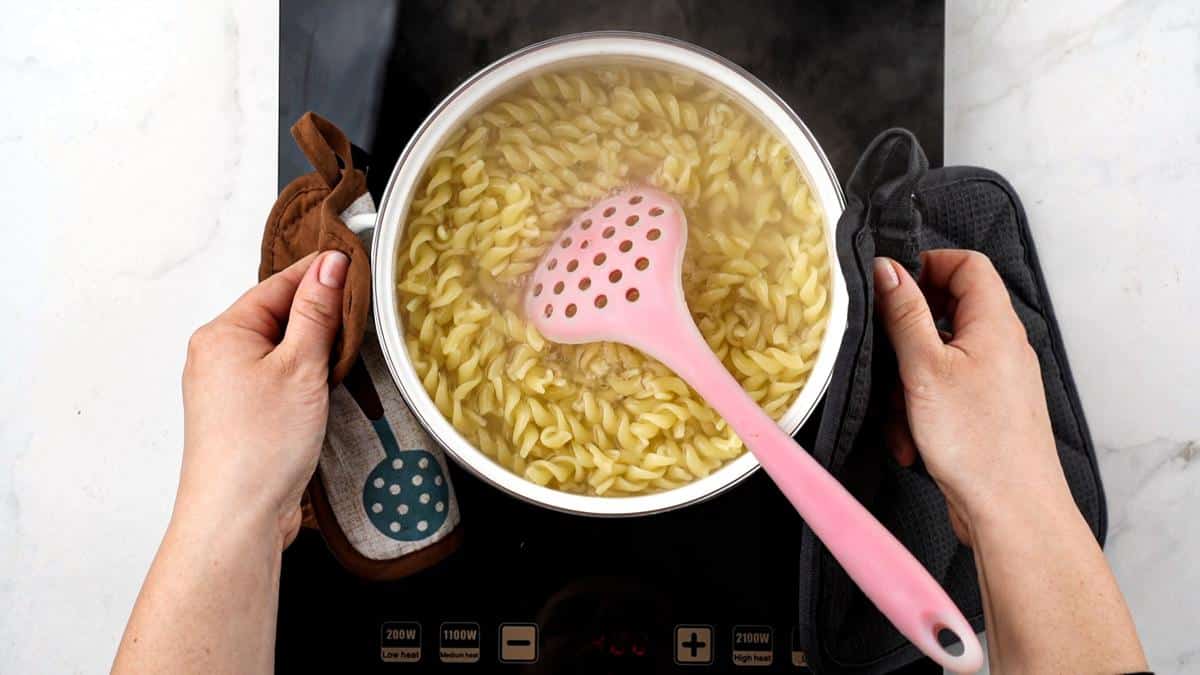 pasta cooking in white pot on hot plate