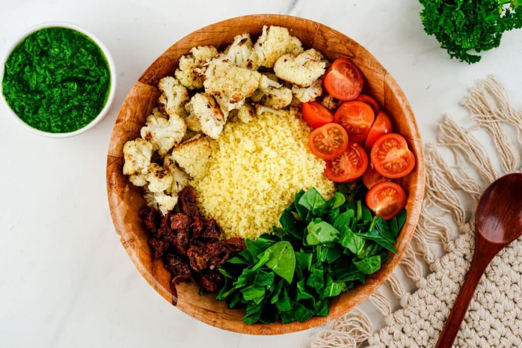 couscous salad ingredients in large wooden bowl before mixing