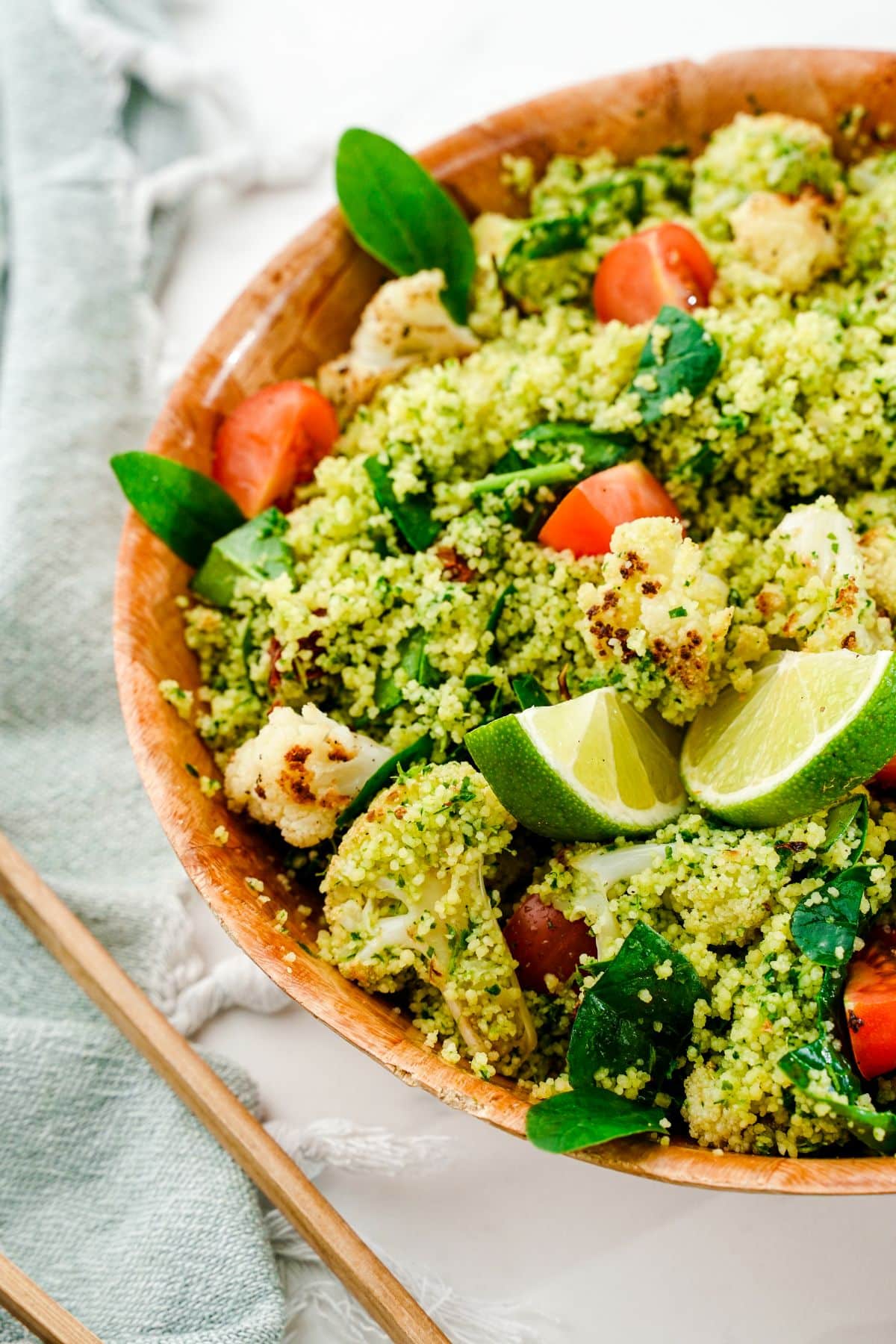 large wood bowl of mediterranean couscous salad on table