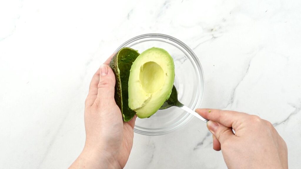 avocado being scooped into bowl
