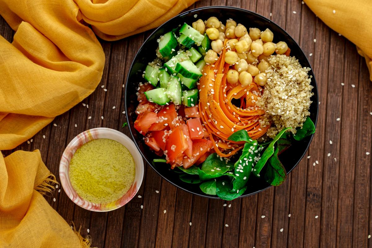 black bowl of rainbow salad on wood table