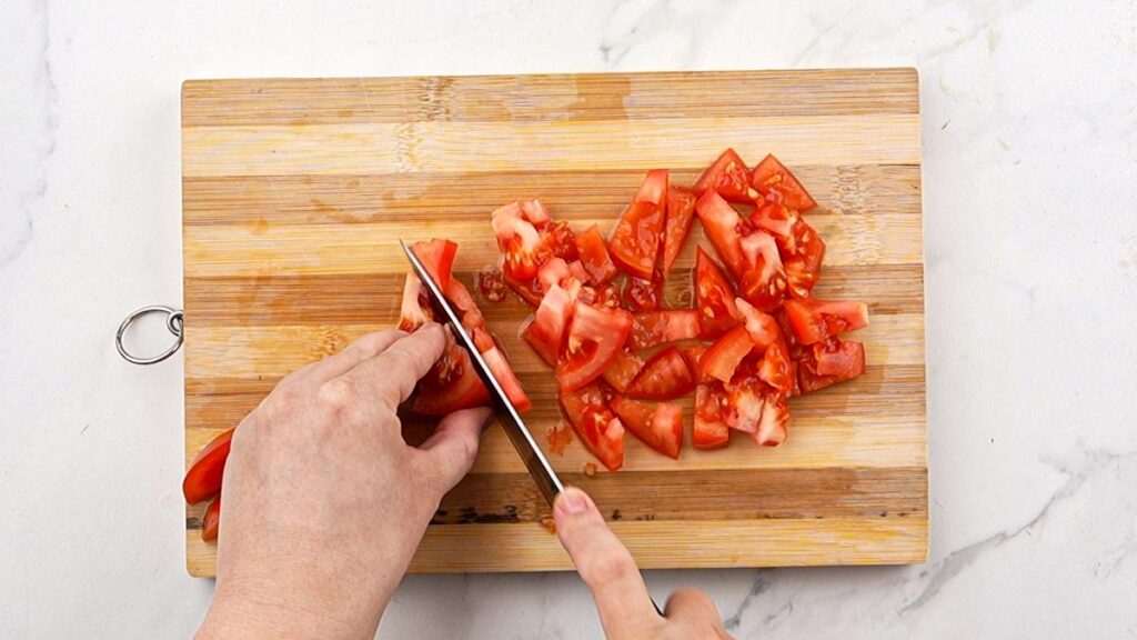 tomatoes being cut on cutting board