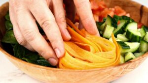 hands arranging vegetabels in bowl