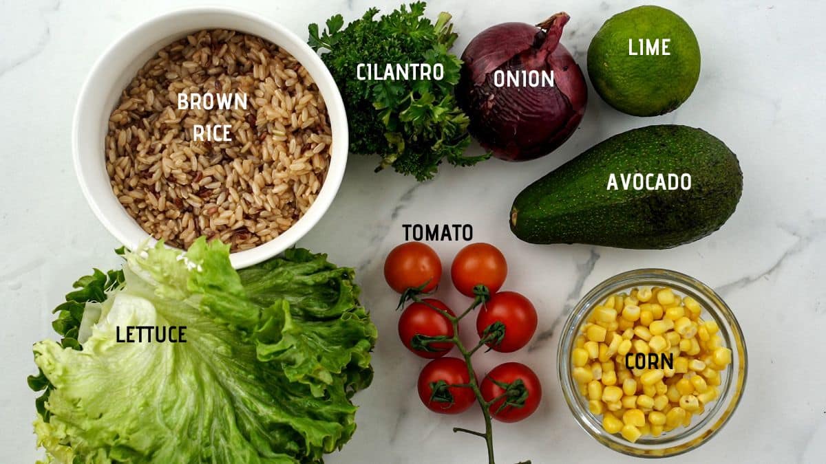 fresh vegetables next to bowl of rice on marble counter