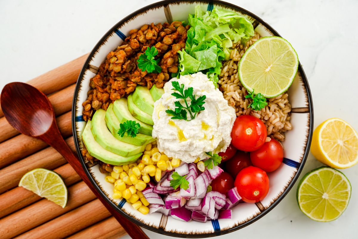 striped bowl on table filled with vegetables and lentils