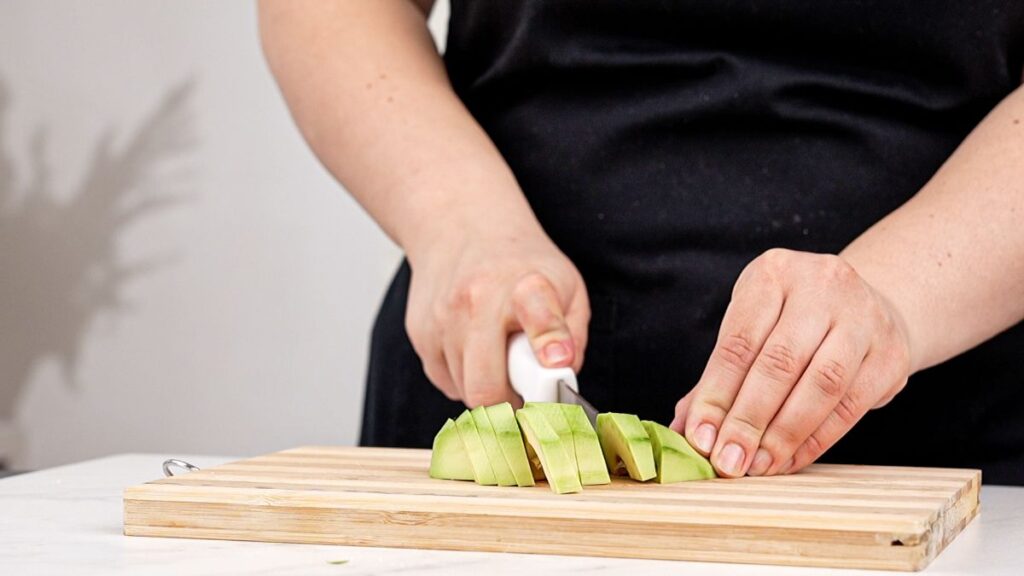 cutting avocado on wood cutting board