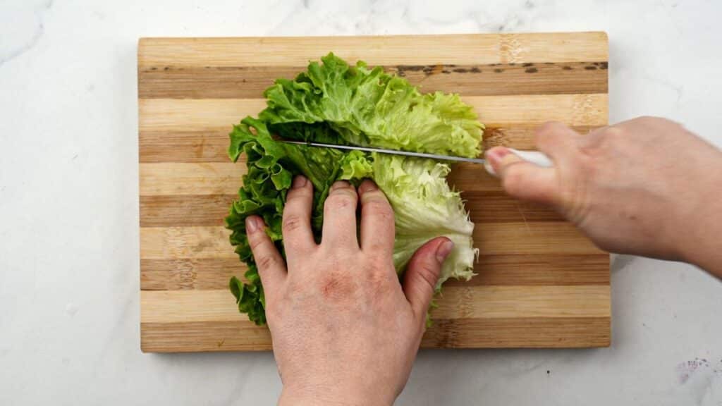 cutting lettuce on wood cutting board