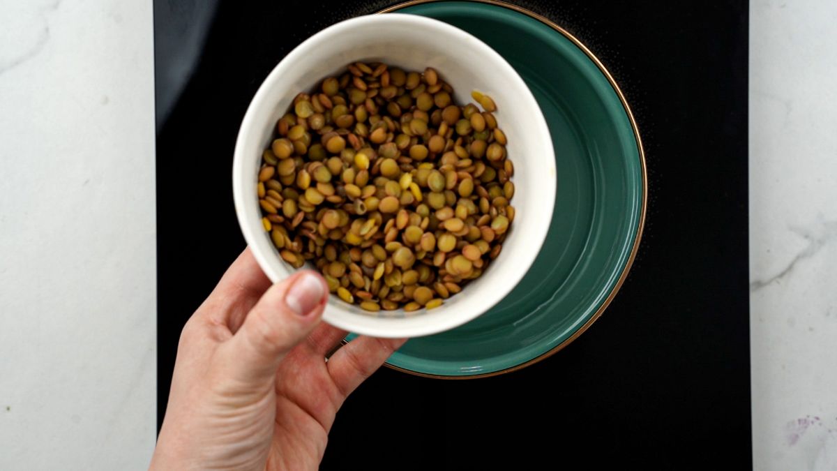 lentils being poured into saucepan