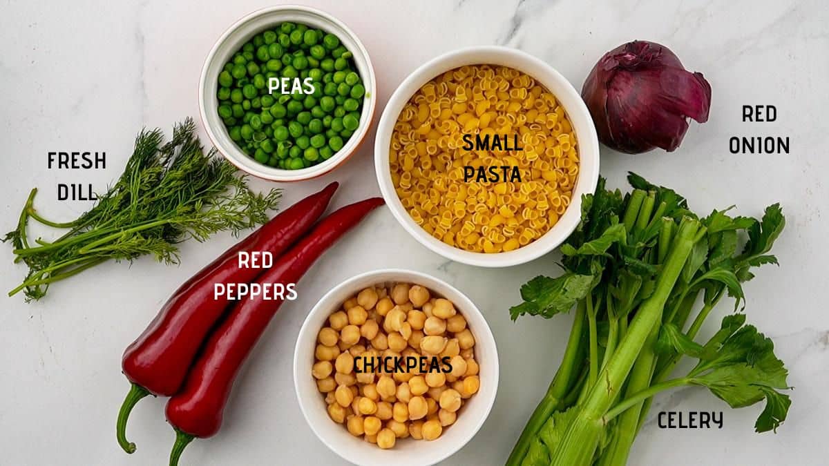 fresh vegetables on table beside bowls of pasta chickpeas and peas