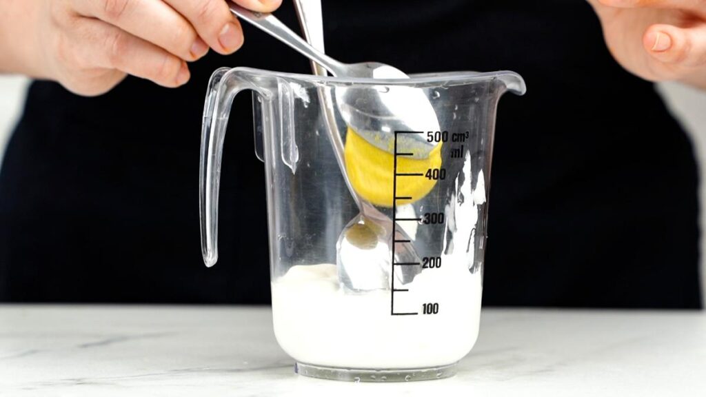 ingredients being poured into glass measuring cup
