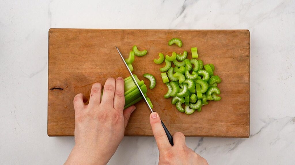 celery being chopped on cutting board