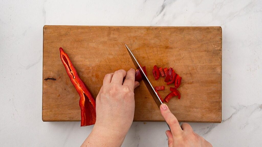 red pepper being chopped on cutting board