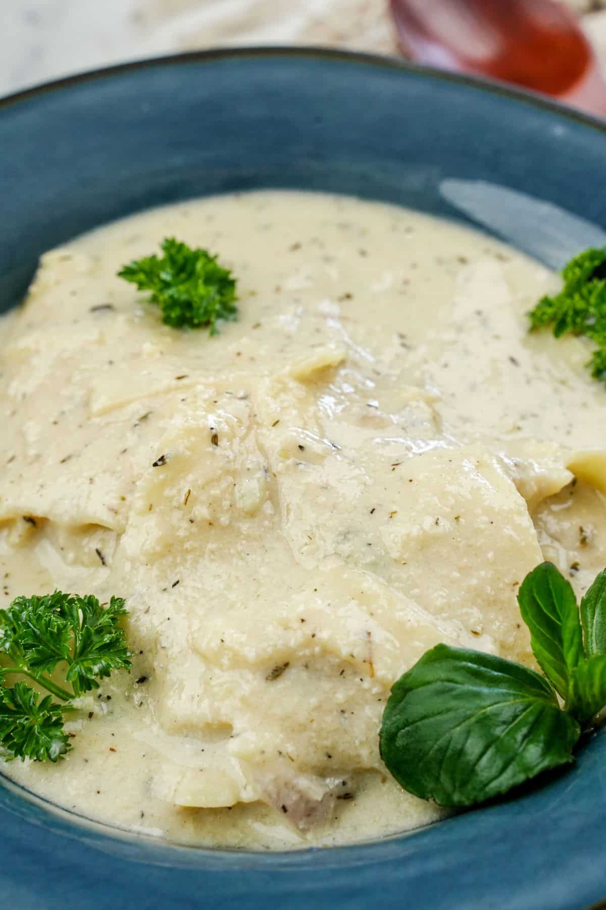 blue bowl of white lasagna soup