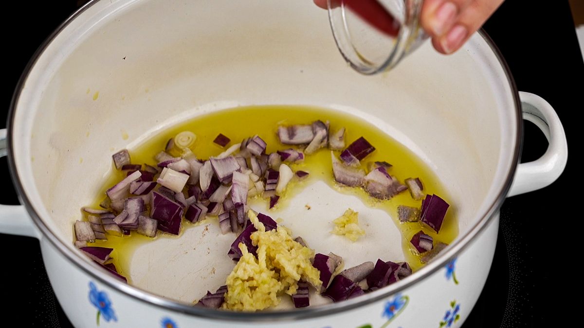 onion and garlic being cooked in saucepan