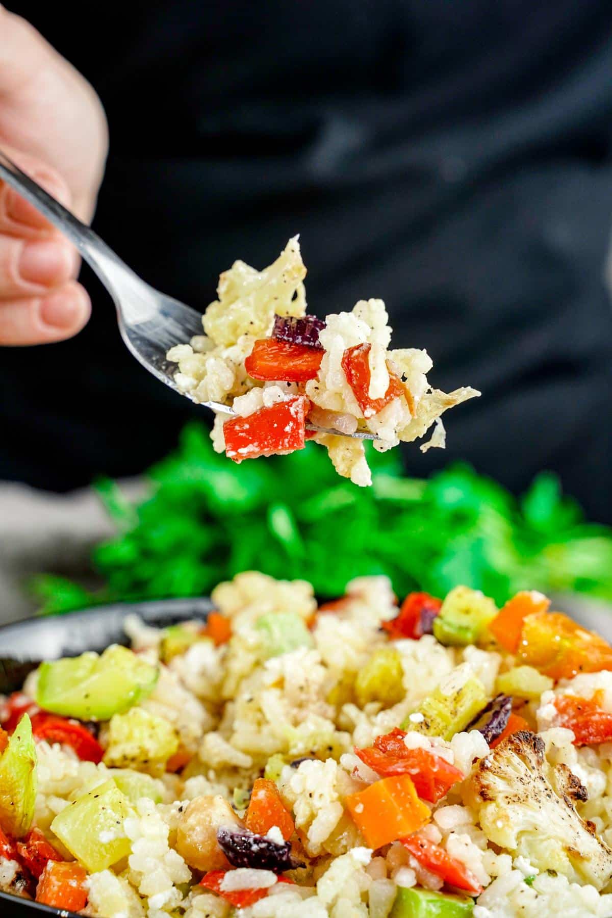 fork of roasted vegetable rice salad above bowl
