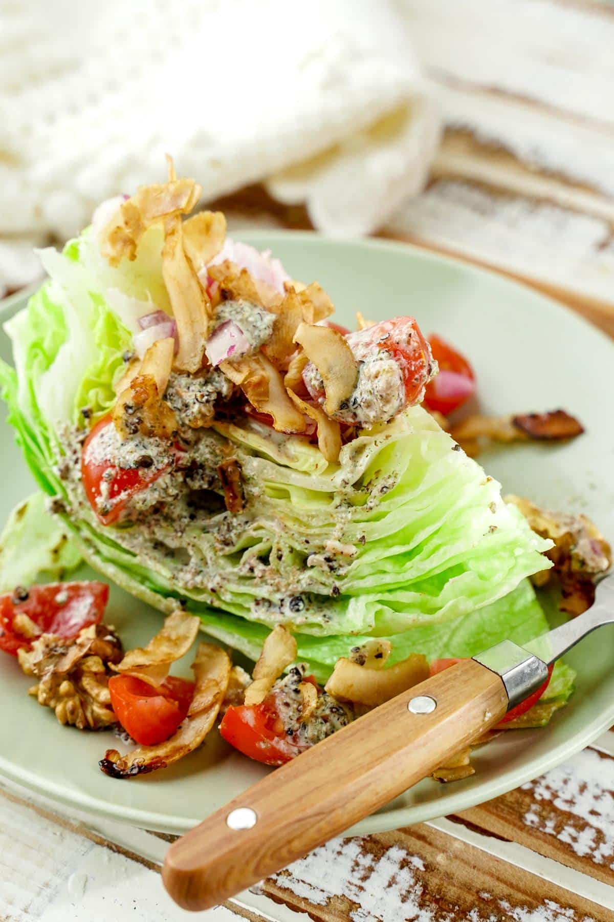 wedge salad on gray plate on top of rustic table