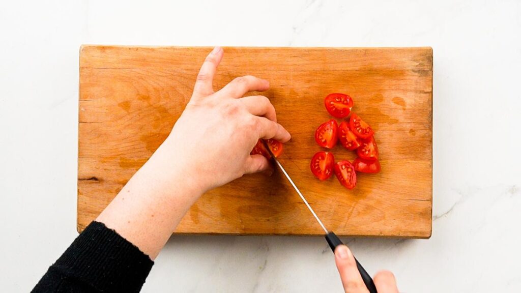 tomatoes being sliced on cutting board