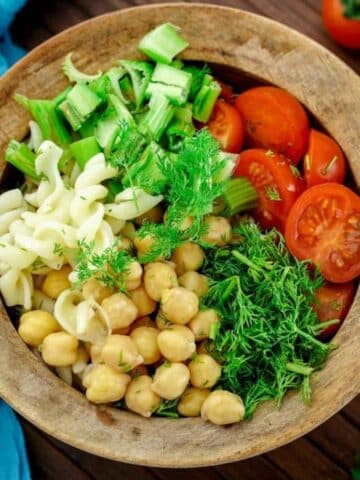 Easy vegan pesto salad served in a wooden bowl.