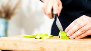 avocado being sliced on wood cutting board