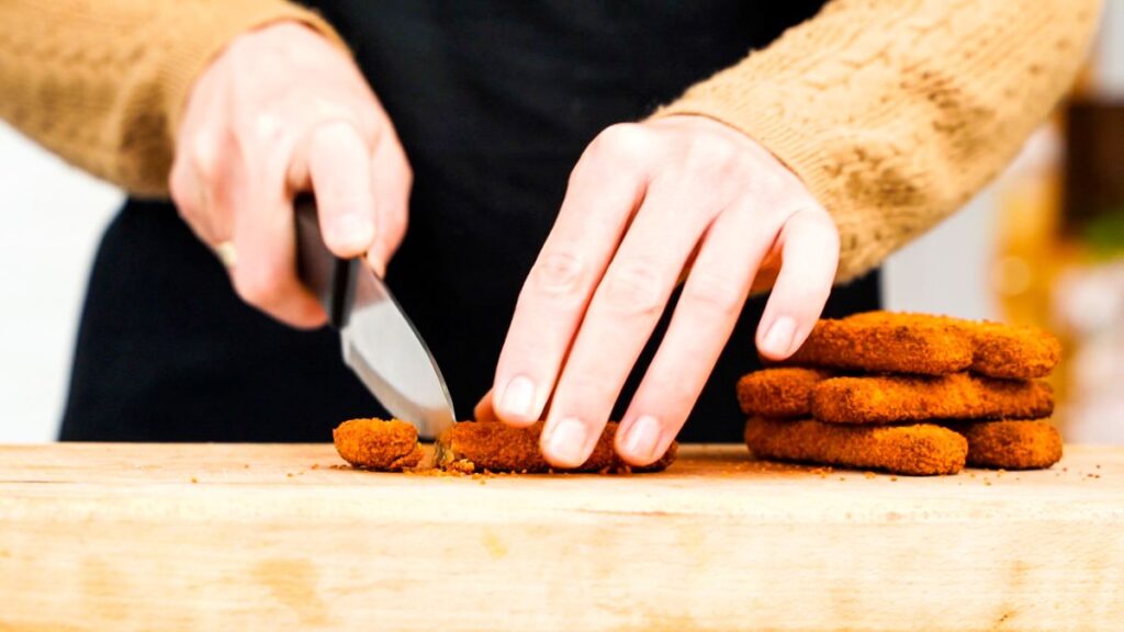 slicing vegan chicken on cutting board