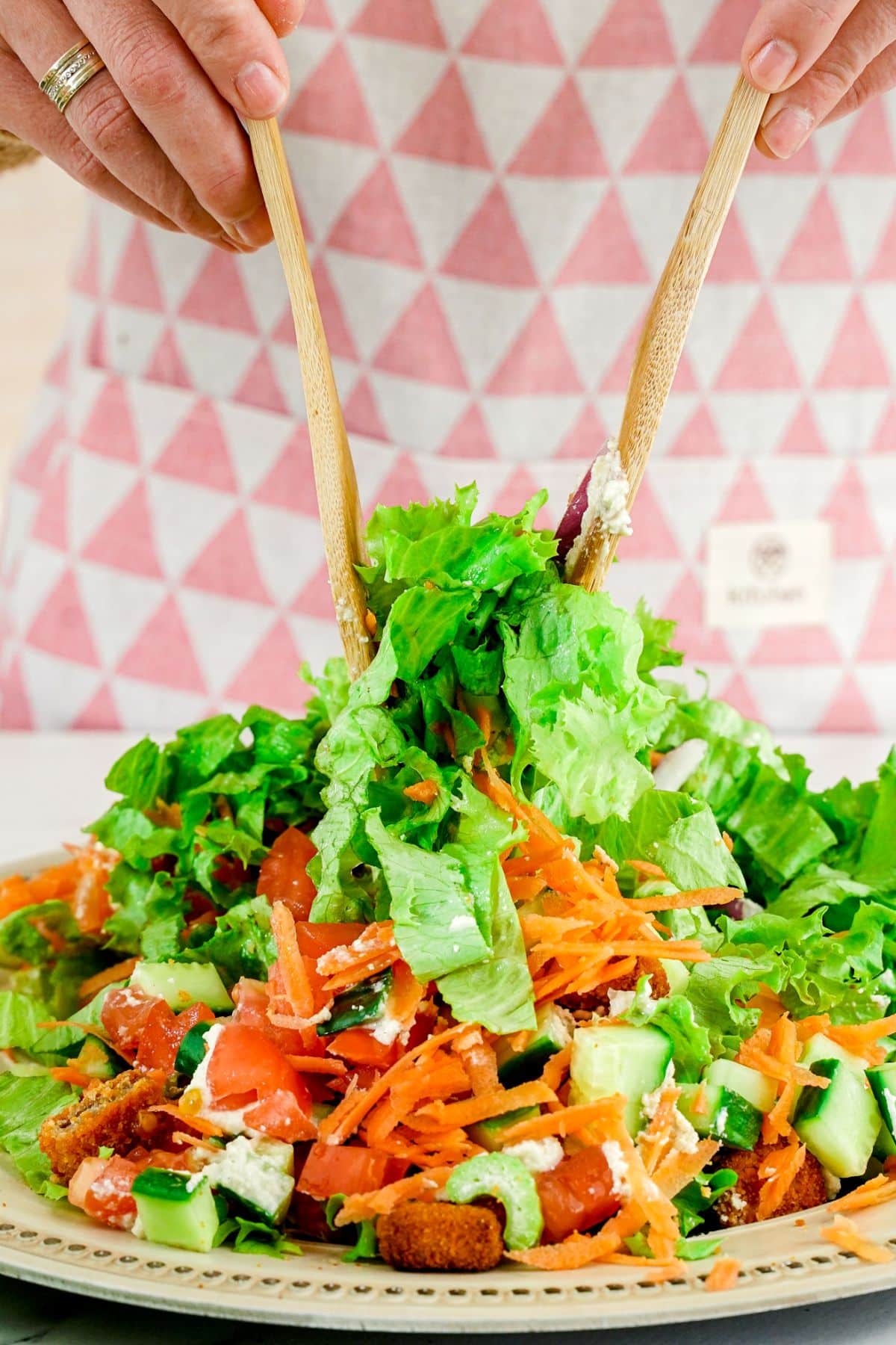 wooden forks tossing salad in bowl