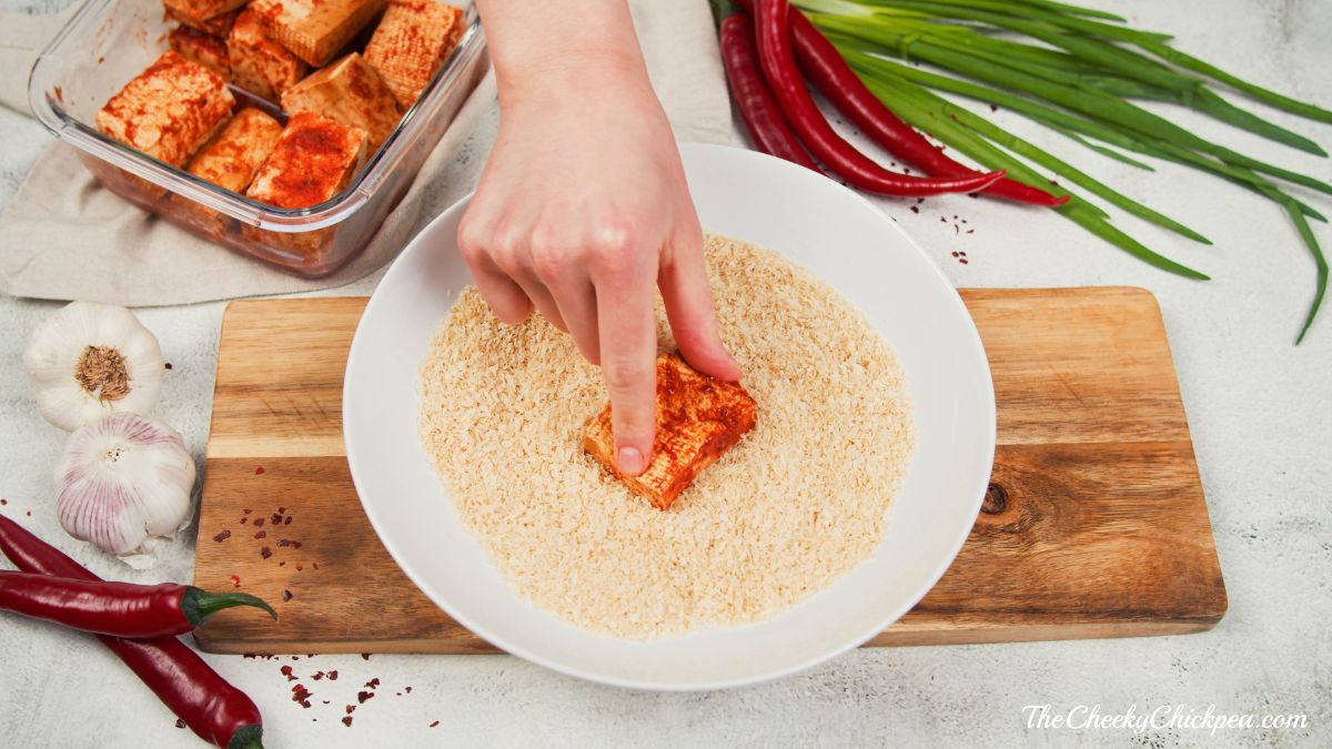 tofu being dredge in breadcrumbs