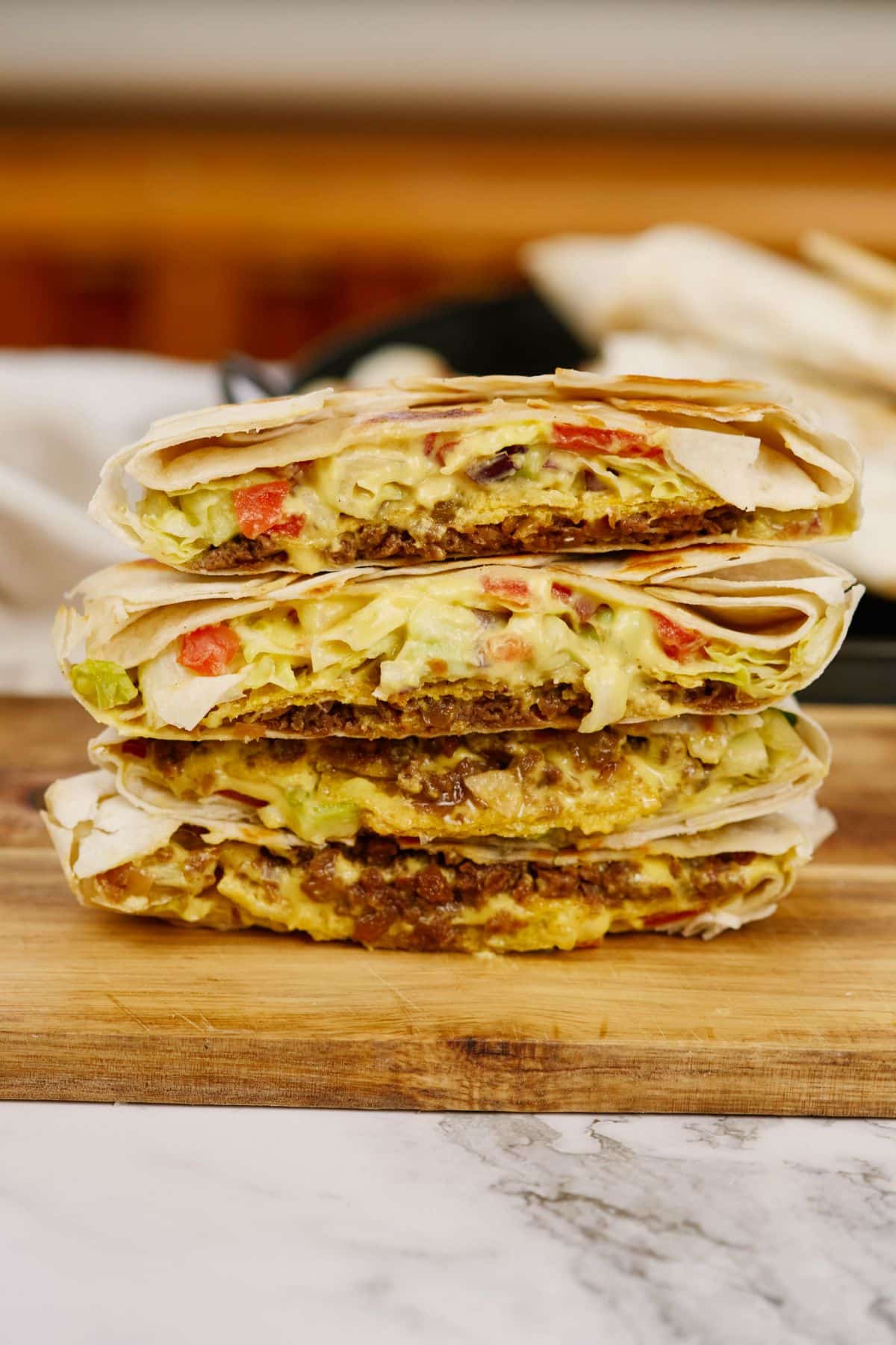 crunchwraps cut in half and stacked on cutting board