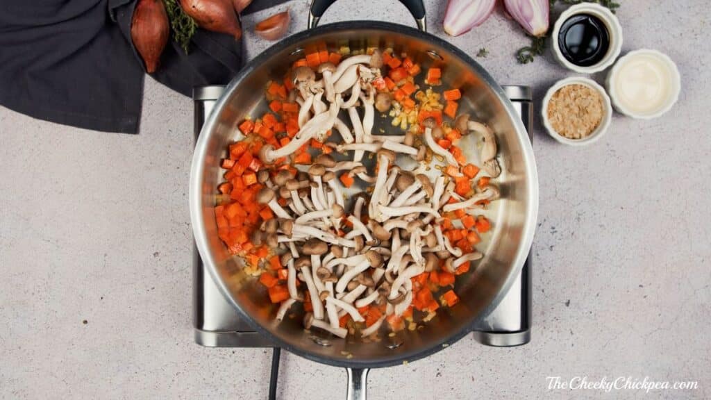mushrooms in pan with carrots on hot plate