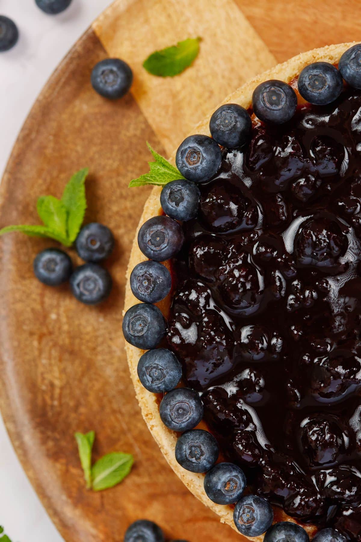 cheesecake on wooden board topped with blueberries