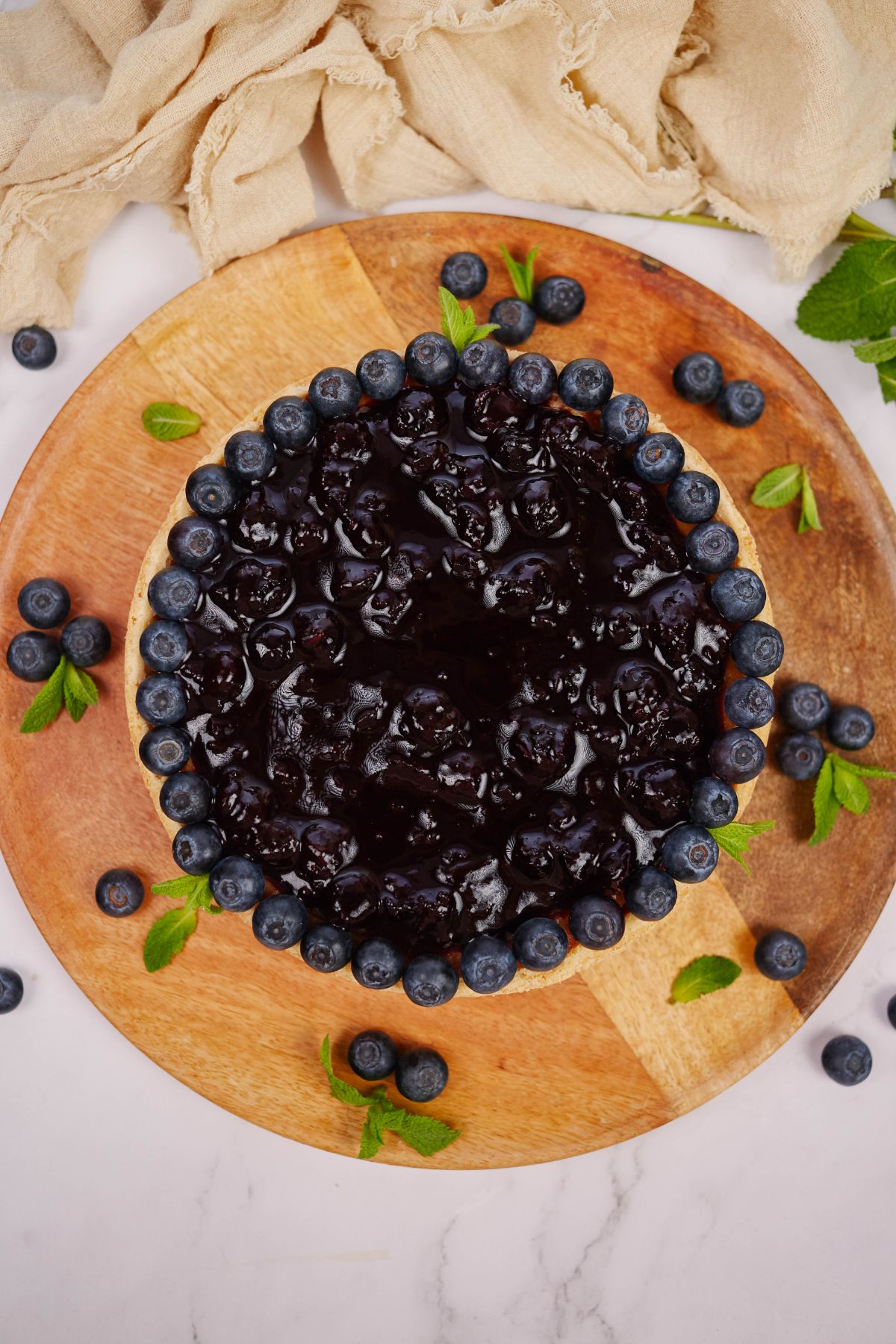 blueberry vegan cashew cheesecake on round wood board
