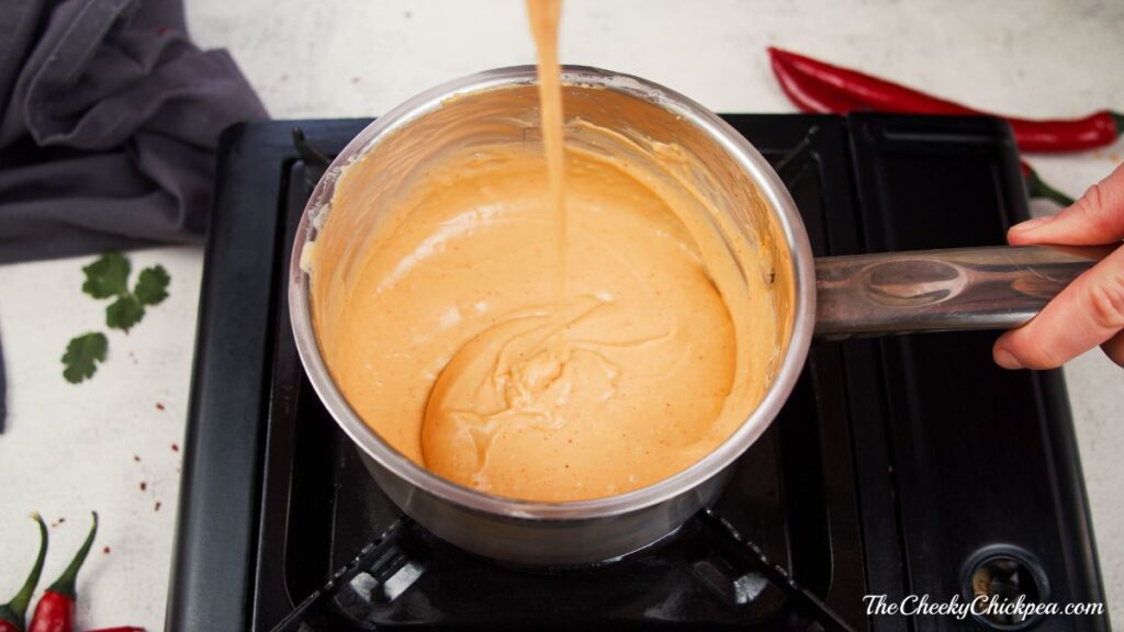 thickened vegan cheese sauce in saucepan on hot plate