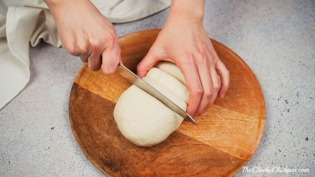 dough being sliced on wood board