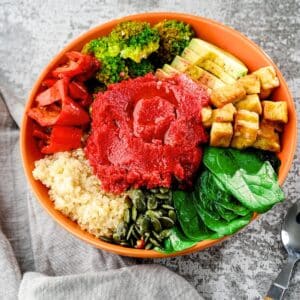 Tofu quinoa beets salad in a wooden bowl.