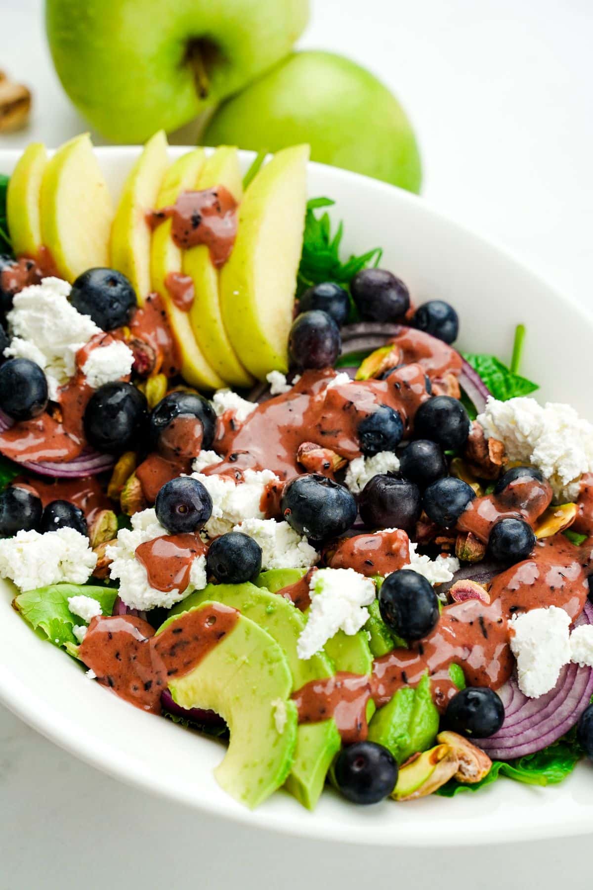 blueberries and apple slices on top of salad with sliced green apples