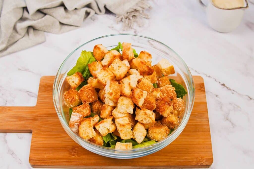 fried tofu chunks on top of salad in glass bowl