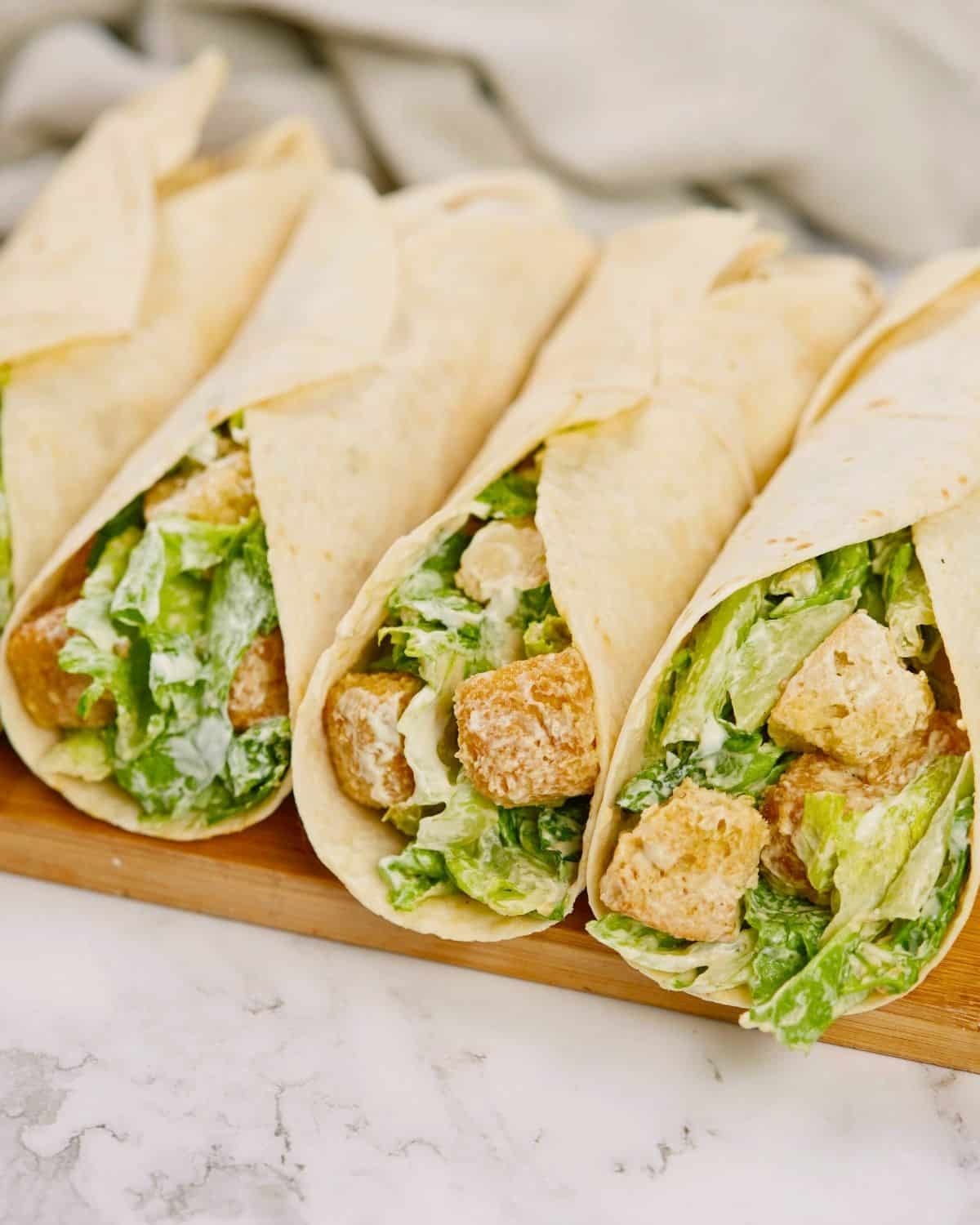wraps filled with lettuce and tofu on wood board