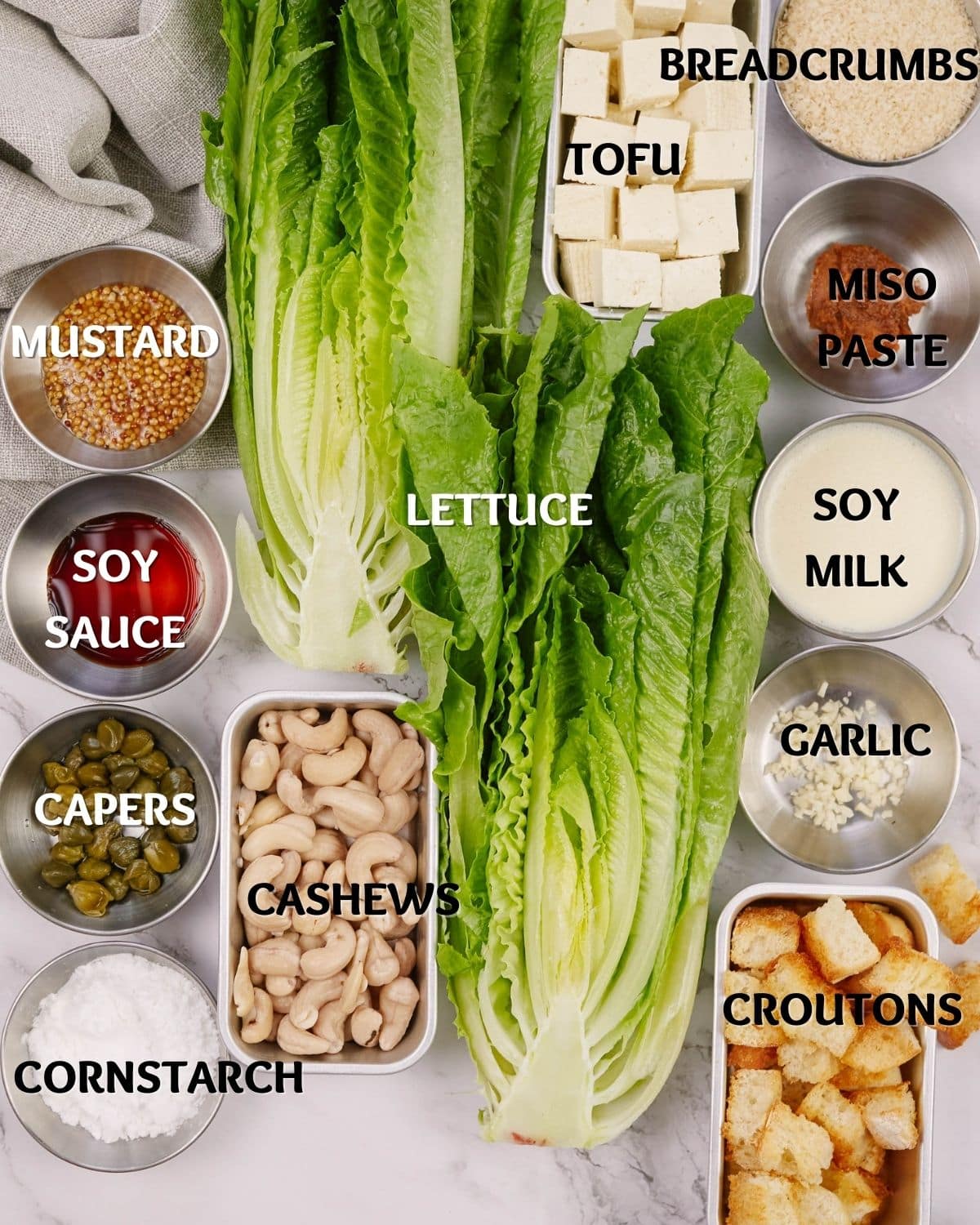 ingredients in ramekins on table next to romaine lettuce