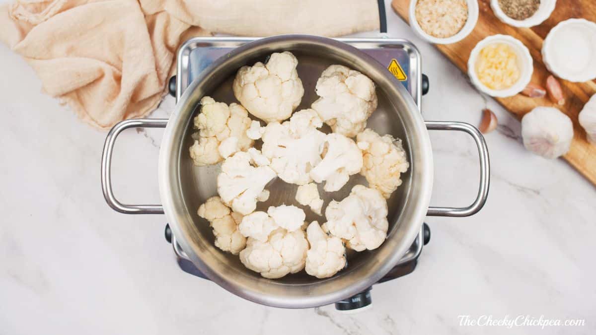 cauliflower being cooked in saucepan