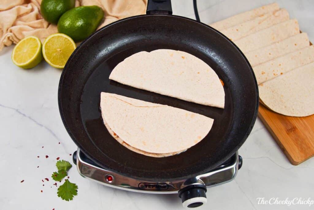 tortillas in skillet on hot plate