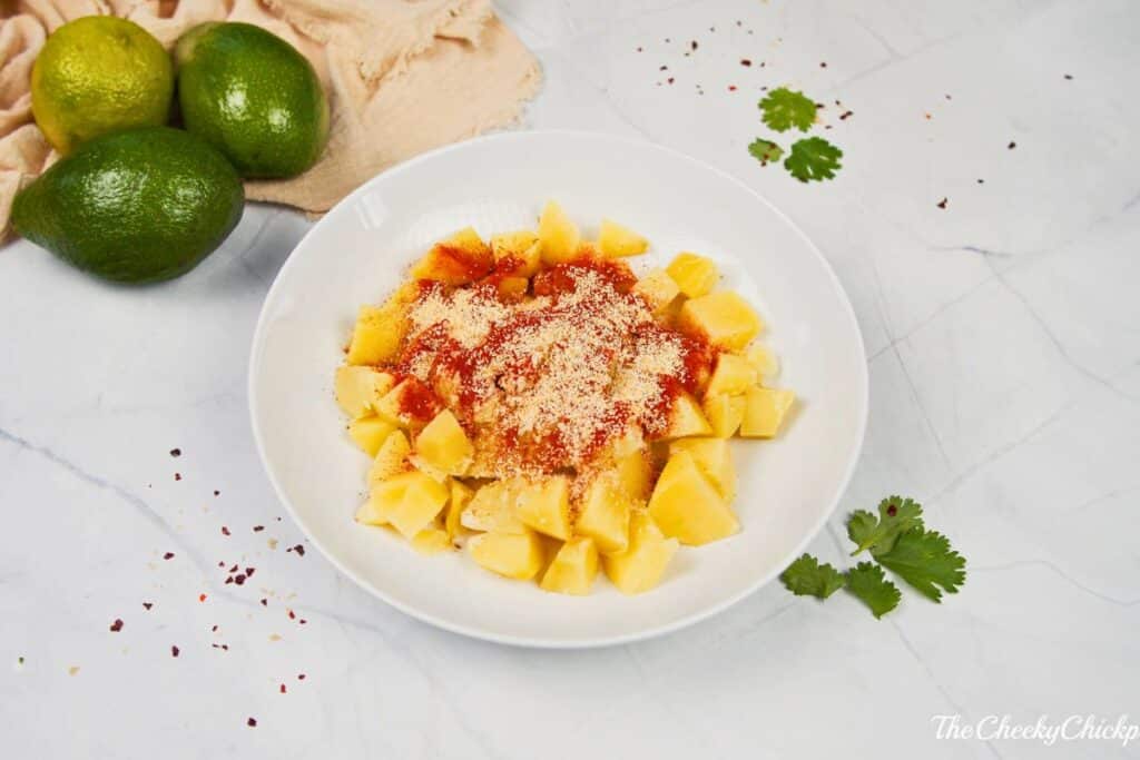 potatoes with herbs and spices on top in white bowl