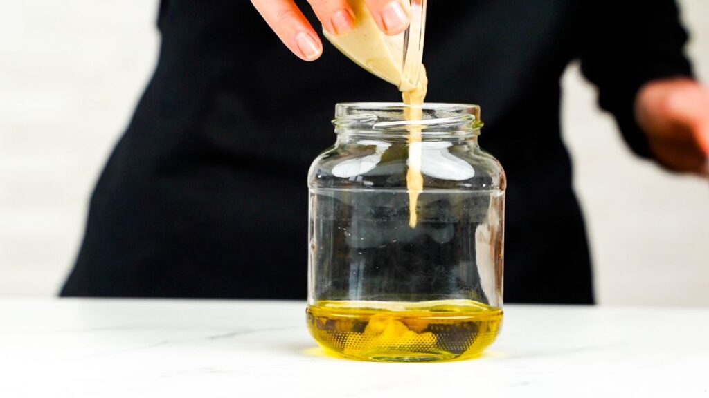 oil being poured into jar