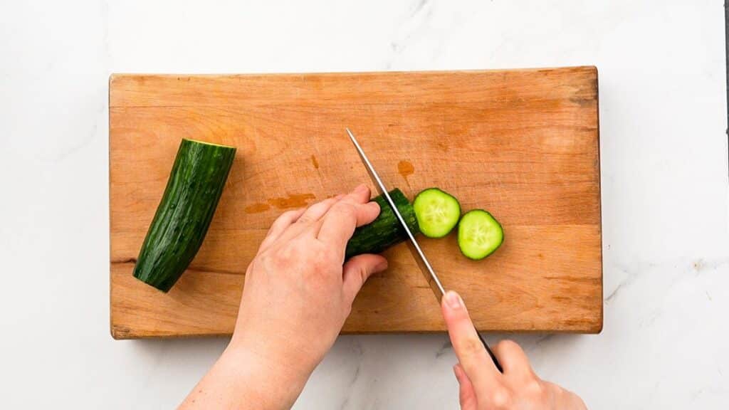 slicing cucumber on cutting board
