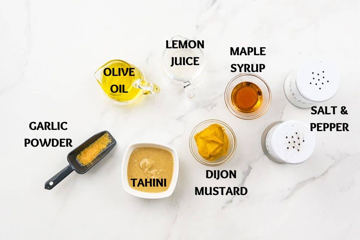 ramekins and glass bowls of ingredients for salad dressing on marble table