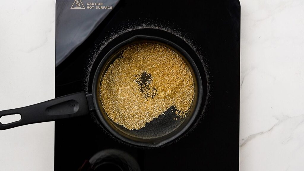 quinoa in black saucepan on hot plate on white table