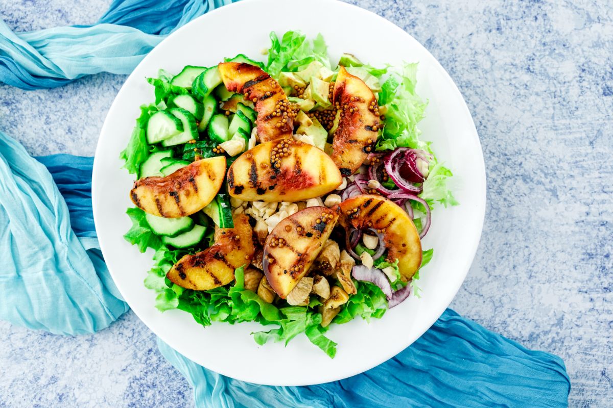 white plate of salad on blue and gray tablecloth